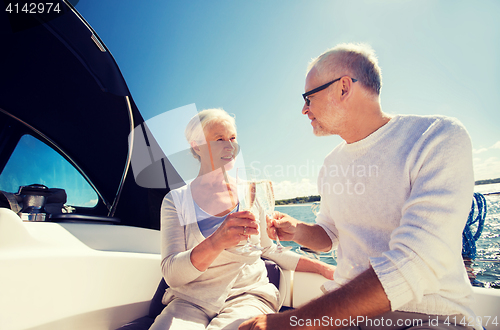 Image of senior couple clinking glasses on boat or yacht