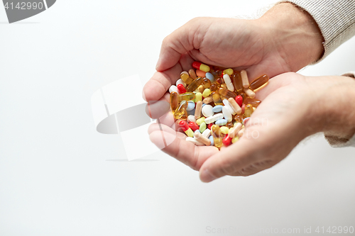 Image of close up of old man hands holding medicine