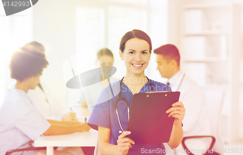 Image of happy doctor over group of medics at hospital