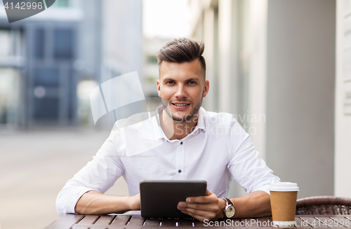 Image of man with tablet pc and coffee at city cafe