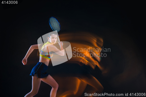 Image of Portrait of beautiful girl tennis player with a racket on dark background