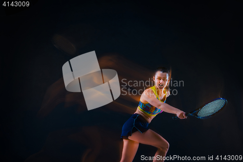 Image of Portrait of beautiful girl tennis player with a racket on dark background