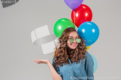 Image of girl with sunglasses and bunch of colorful balloons