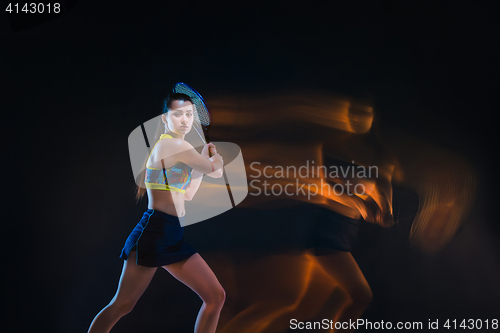 Image of Portrait of beautiful girl tennis player with a racket on dark background