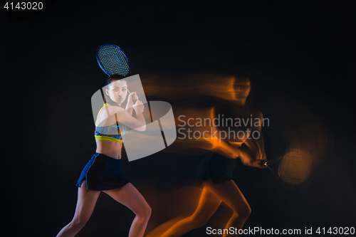 Image of Portrait of beautiful girl tennis player with a racket on dark background