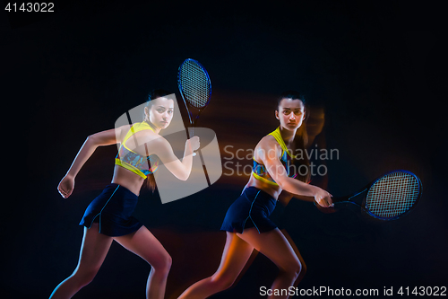 Image of Portrait of beautiful girl tennis player with a racket on dark background