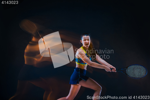 Image of Portrait of beautiful girl tennis player with a racket on dark background