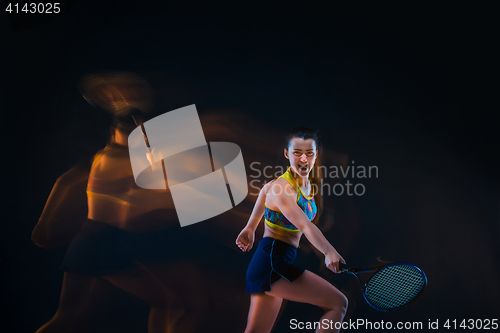 Image of Portrait of beautiful girl tennis player with a racket on dark background