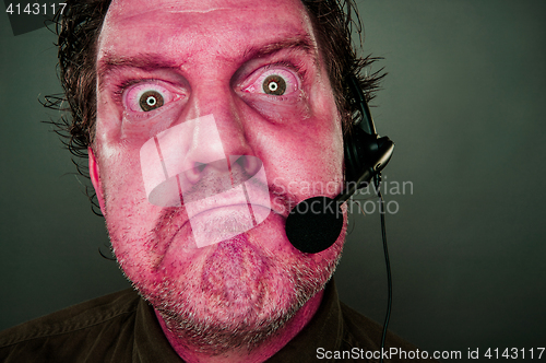 Image of Grumpy Red Eyes and Face Customer Support Man with Headset