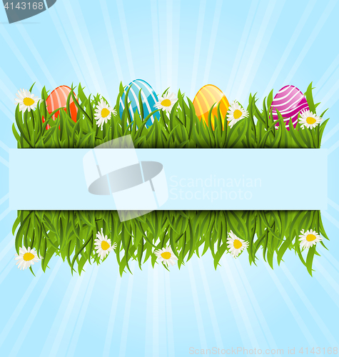 Image of Easter colorful eggs and camomiles in green grass with space for