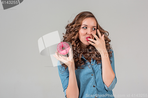 Image of The smiling girl on gray studio background with round cake