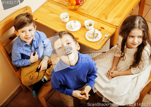 Image of little cute boys eating dessert on wooden kitchen. home interior. smiling adorable friendship together forever friends, lifestyle people concept