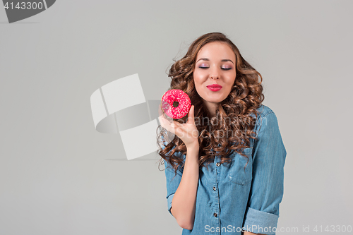 Image of The smiling girl on gray studio background with round cake