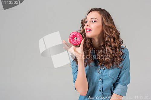 Image of The smiling girl on gray studio background with round cake