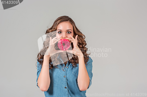 Image of The smiling girl on gray studio background with round cake