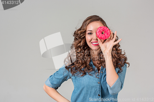 Image of The smiling girl on gray studio background with round cake