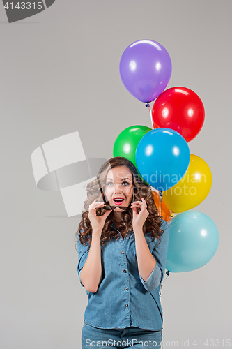 Image of girl with sunglasses and bunch of colorful balloons