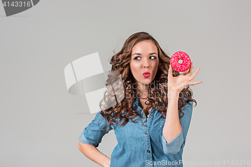 Image of The smiling girl on gray studio background with round cake