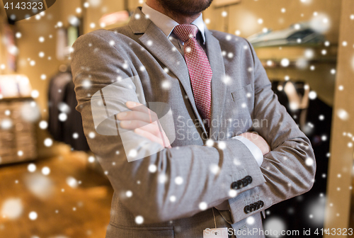 Image of close up of man in suit and tie at clothing store