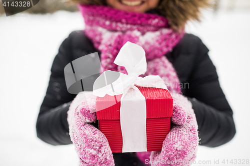 Image of close up of woman with christmas gift outdoors