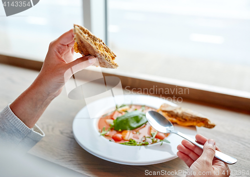 Image of woman eating gazpacho soup at restaurant