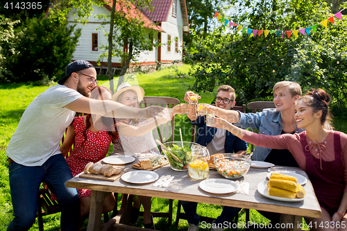 Image of happy friends having party at summer garden