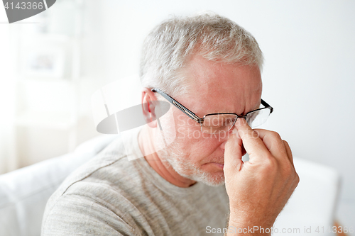 Image of senior man suffering from headache at home