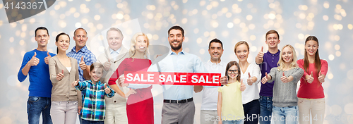 Image of happy people with sale sign showing thumbs up