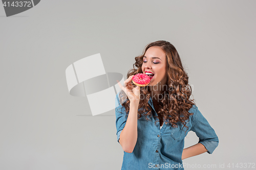 Image of The smiling girl on gray studio background with round cake