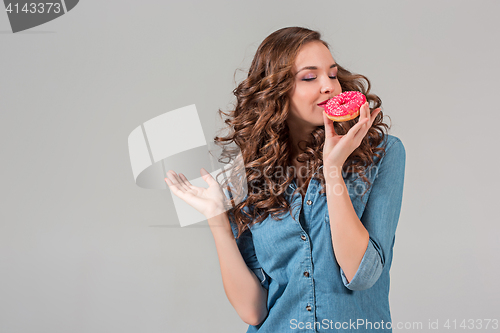 Image of The smiling girl on gray studio background with round cake