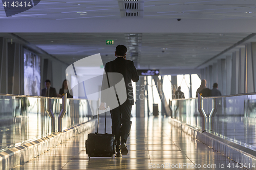 Image of Businessman at airport corridor walking to departure gates.