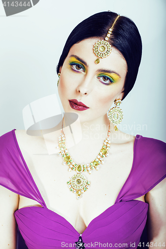 Image of young pretty caucasian woman like indian in ethnic jewelry close up on white, bridal makeup