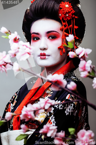 Image of young pretty geisha in kimono on white background