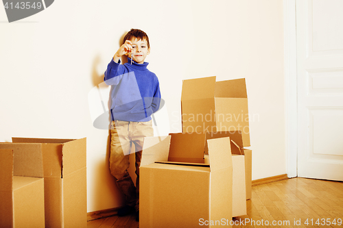 Image of little cute boy in empty room, remoove to new house. home alone, lifestyle people concept