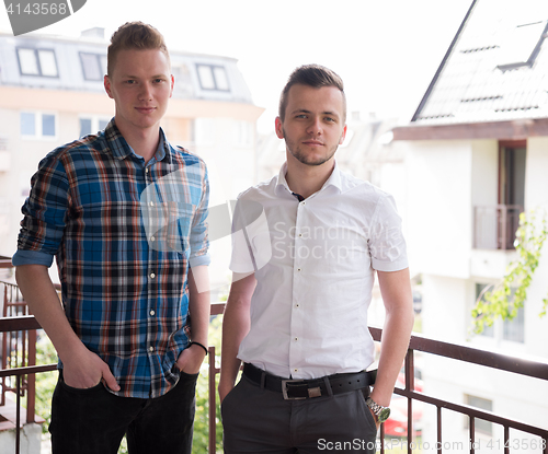 Image of two young men standing at balcony