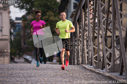 Image of multiethnic couple jogging in the city