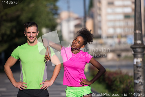 Image of portrait of young multietnic jogging couple ready to run