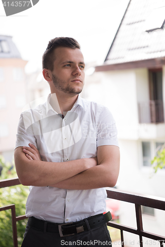 Image of man standing at balcony