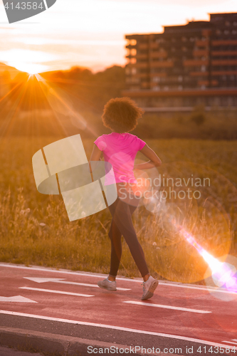 Image of a young African American woman jogging outdoors