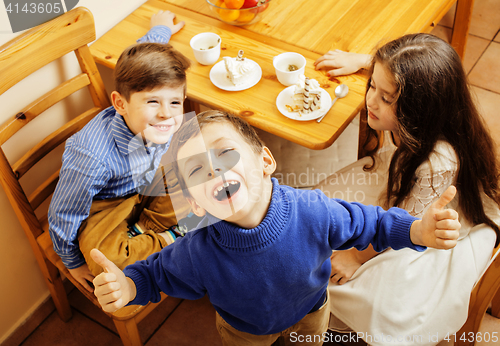 Image of little cute boys eating dessert on wooden kitchen. home interior. smiling adorable friendship together forever friends, lifestyle people concept