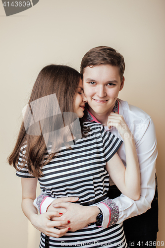 Image of couple of happy smiling teenagers students, warm colors having a kiss, lifestyle people concept