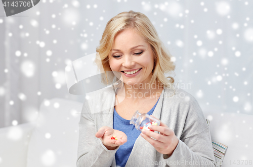 Image of happy middle aged woman with medicine at home