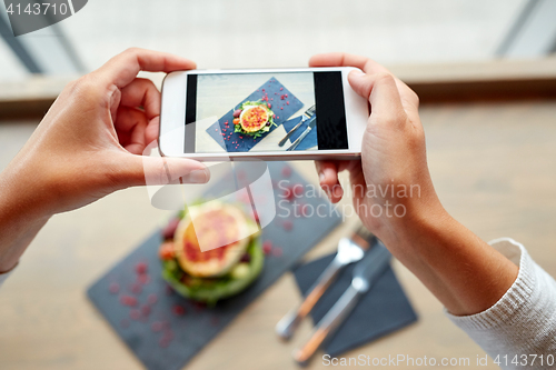 Image of hands with smartphone photographing food