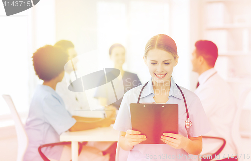 Image of happy doctor over group of medics at hospital