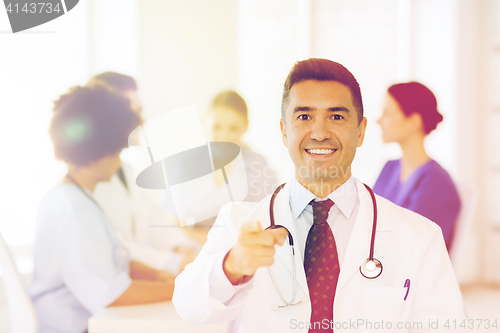 Image of happy doctor over group of medics at hospital