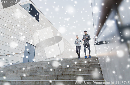 Image of couple of sportsmen running downstairs outdoors