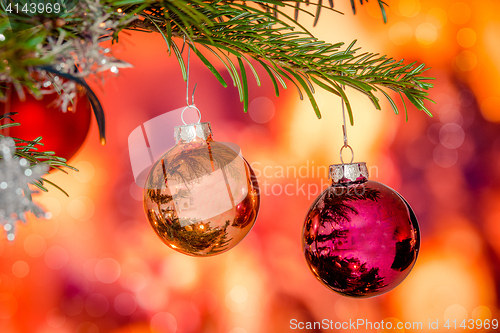 Image of Shiny Christmas baubles hanging on a branch