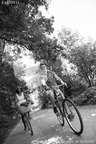 Image of Young multiethnic couple having a bike ride in nature