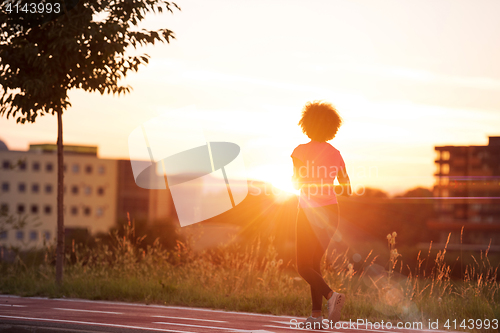 Image of a young African American woman jogging outdoors