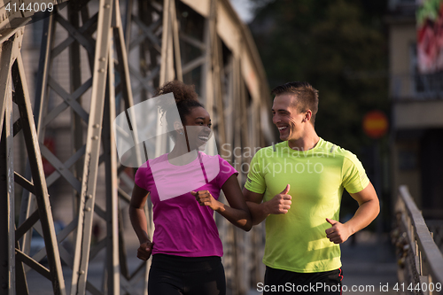 Image of multiethnic couple jogging in the city